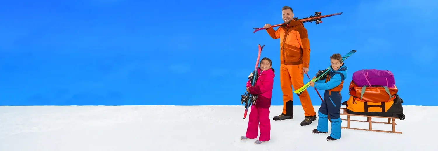 Familie mit Skiern und Schlitten freut sich auf die Sportferien