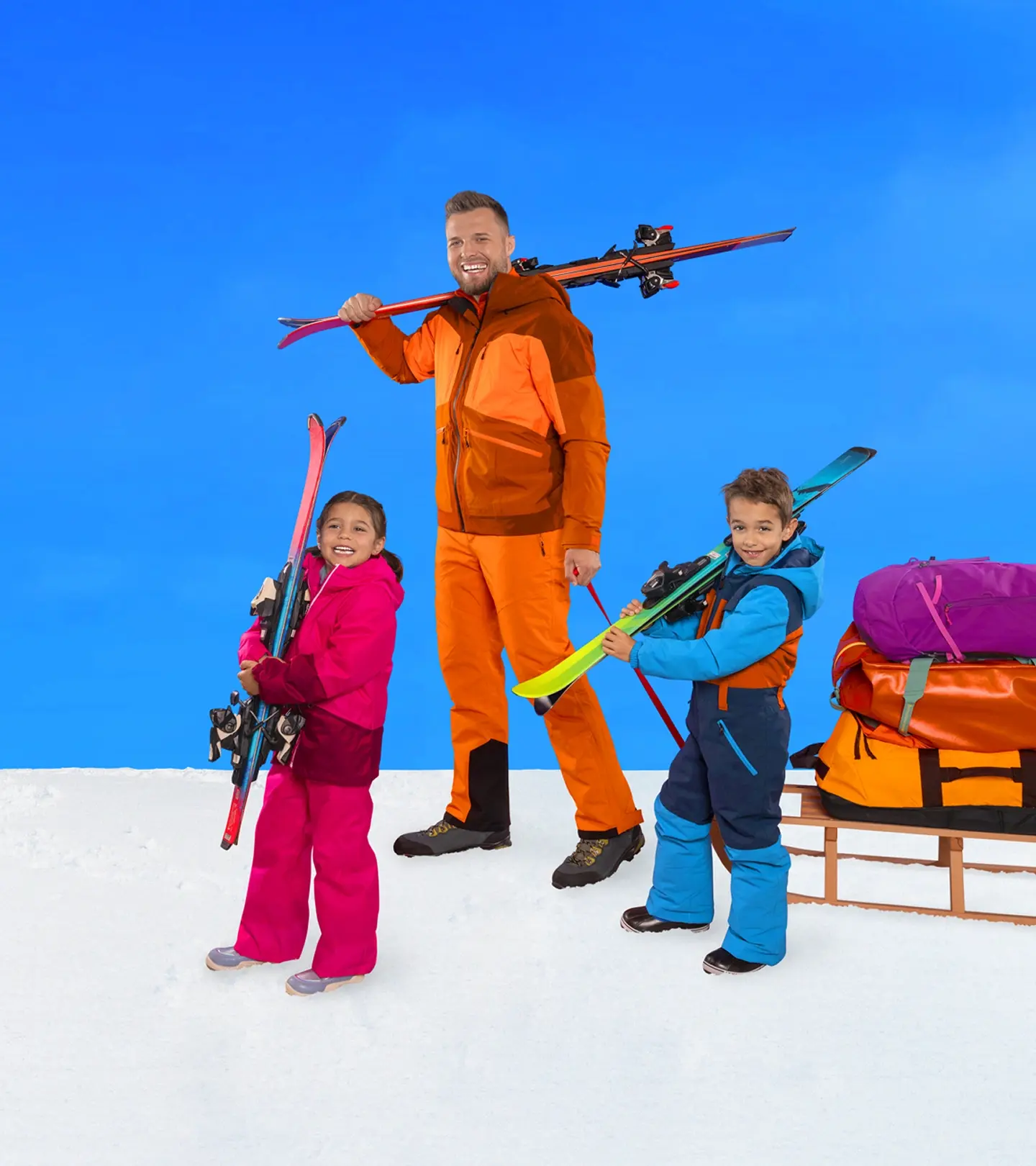 Familie mit Skiern und Schlitten freut sich auf die Sportferien